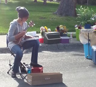a teenager playing music at a farmer's market